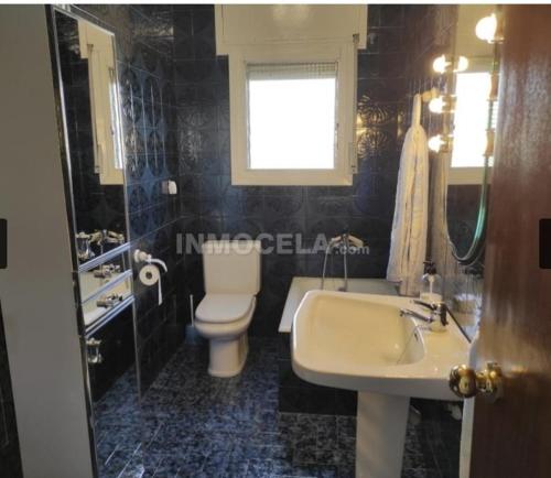 a bathroom with a white sink and a toilet at Casa La Torre de la Balsa de Cela 