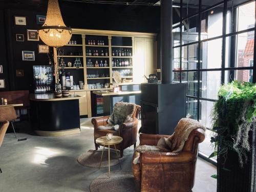 a bar with two chairs and a table in a room at Logerij De Schuur in Zierikzee