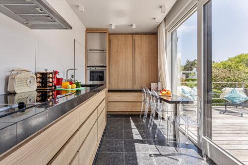 a kitchen with a counter and a table with chairs at Villa Stuifduin in Oostduinkerke