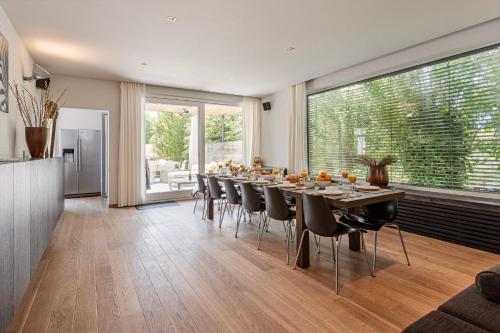 a large dining room with a long table and chairs at Villa Stuifduin in Oostduinkerke