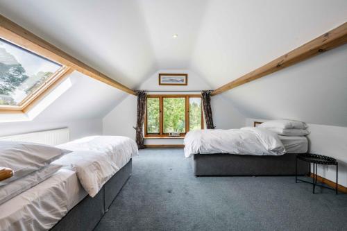 a attic bedroom with two beds and a window at Millwood in Horstead