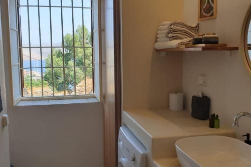 baño con lavabo y ventana en Boho luxury studio in Kali Strata, en Symi