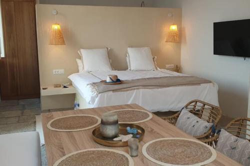 Un dormitorio con una cama y una mesa de madera con una mesa. en Boho luxury studio in Kali Strata, en Symi