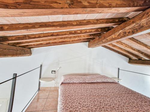 - une chambre avec un lit dans une pièce dotée de plafonds en bois dans l'établissement Loft Honeymoon Rio Elba old town, à Rio nellʼElba