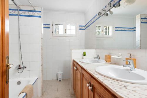 y baño con 2 lavabos y ducha. en Villa Cala Llonga, en Mahón