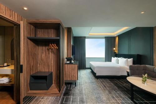 een hotelkamer met een bed en een bank bij Mercure Tangerang Centre in Tangerang