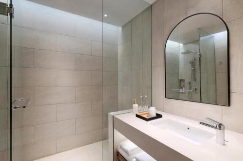 a bathroom with a sink and a mirror at Mercure Tangerang Centre in Tangerang