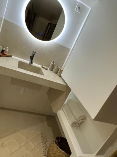 une salle de bain avec un lavabo et un miroir dans l'établissement Appartement jacuzzi privé, à Avignon
