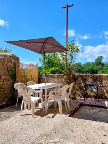 a table and chairs with an umbrella on a patio at La Casetta di Quercia in Olivola