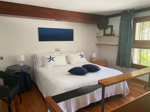 una camera da letto con un grande letto bianco con cuscini blu di La Valle B&B a Brescia