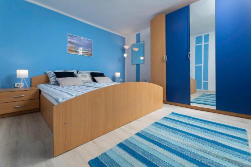 a blue bedroom with a bed and a blue wall at Villa Meri in Gabonjin