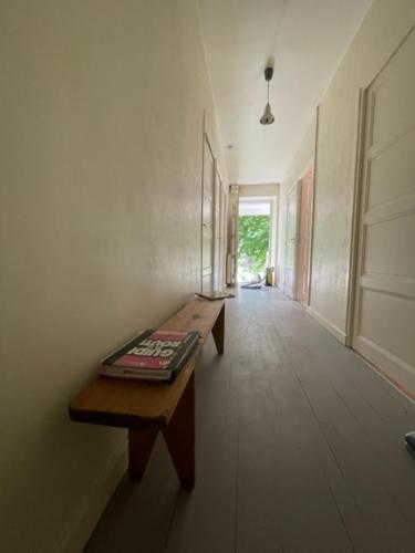- un couloir avec un banc et une table dans une chambre dans l'établissement Gîte Maison Fougères droite Saint-Préjet d'Allier 14 personnes, à Saint-Préjet-dʼAllier