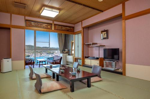 a living room with a table and chairs at Ama no Shima in Toba