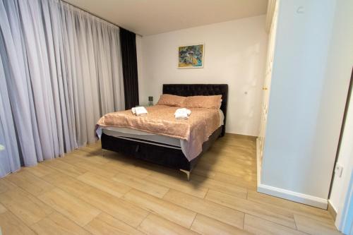 1 dormitorio con 1 cama y suelo de madera en Mi Casa, en Vrdnik