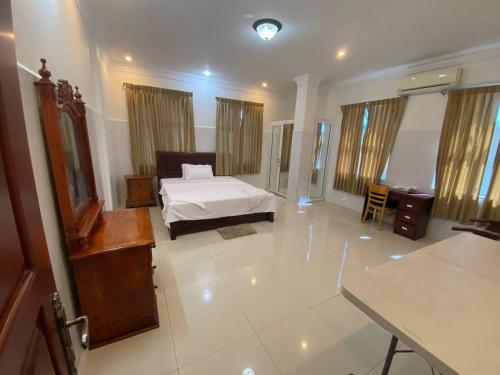 ein Schlafzimmer mit einem Bett und einem Tisch in einem Zimmer in der Unterkunft Old Durbar Skybar & Hotel in Phnom Penh