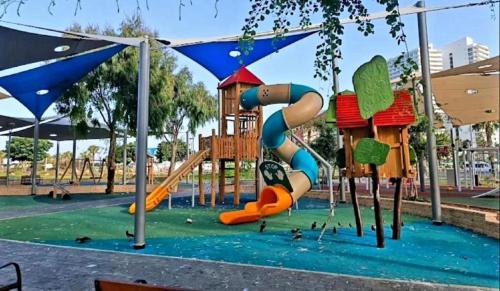 a park with a playground with a slide at Motel Hofim in Bat Yam