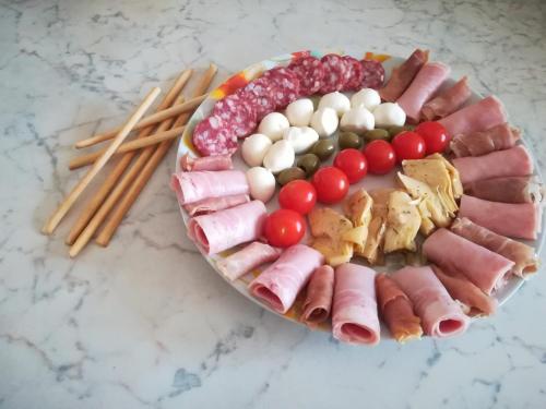 a platter of meats and vegetables on a table at Casa Giada sul mare in Torrenova