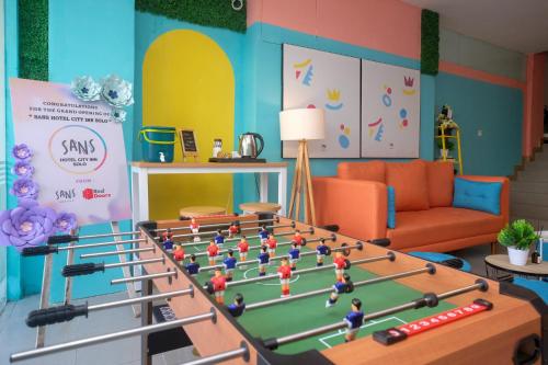 una sala de estar con una mesa grande con un partido de fútbol en Sans Hotel City Inn Solo by RedDoorz en Solo