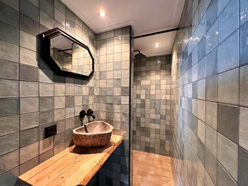 een badkamer met een wastafel en een spiegel bij Pleisterplaats Schöppert B&B in Neede