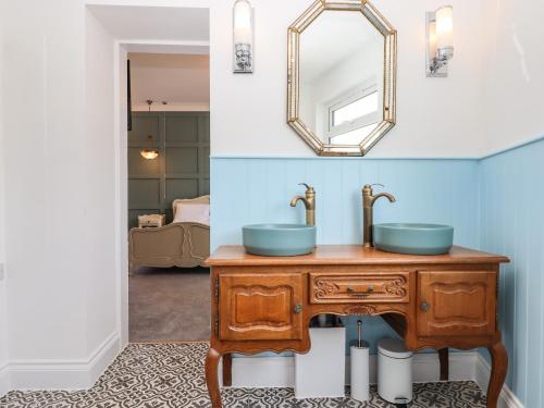 W łazience znajduje się drewniana umywalka i lustro. w obiekcie Bradley House w mieście Ilfracombe