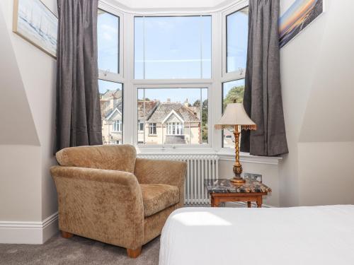 sypialnia z krzesłem i oknem w obiekcie Bradley House w mieście Ilfracombe