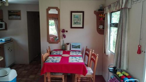 uma sala de jantar com uma mesa vermelha e cadeiras em Mobilhome Camping Paradijs em Zlatá Koruna