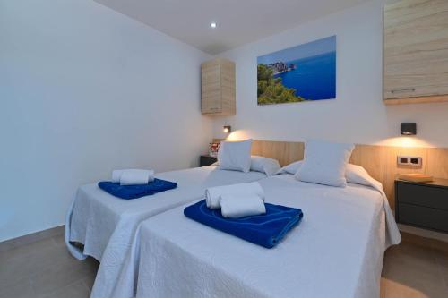 a bedroom with two beds with blue cushions at Mercedes in Jávea