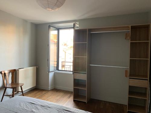 ein Schlafzimmer mit einem Schrank, einem Bett und einem Fenster in der Unterkunft Le calme au coeur de Chauvigny in Chauvigny