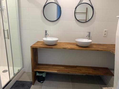 ein Badezimmer mit zwei Waschbecken und zwei Spiegeln in der Unterkunft Le calme au coeur de Chauvigny in Chauvigny