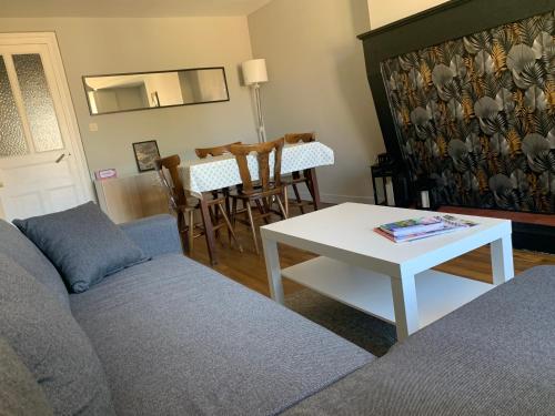 una sala de estar con un sofá y una mesa en Le calme au coeur de Chauvigny, en Chauvigny