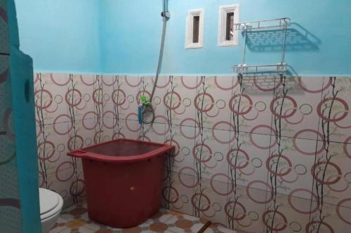 a bathroom with a toilet and a trash can at OYO 91477 Fazira Home Stay Syariah in Halangan