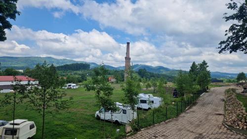 einen Blick auf ein Kraftwerk mit auf einem Feld geparkten Fahrzeugen in der Unterkunft Kemping Stawy Marcowe w Głuszycy in Głuszyca