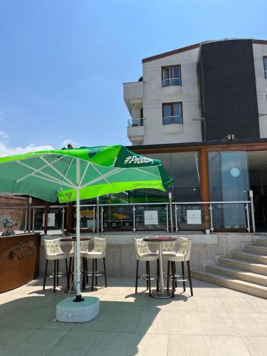 a table and chairs with an umbrella in front of a building at DOUBLE ROYAL HOTEL in Kocaeli