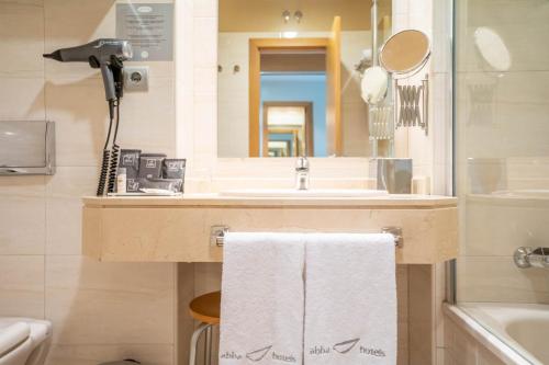 bagno con lavandino e specchio di Abba Comillas Hotel a Comillas