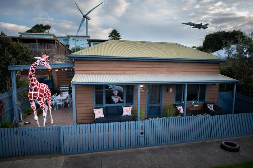 a giraffe is standing in front of a house at Want extra FREE nighly stays added to your booking Shoot me a message before you book to find out how in Queenscliff