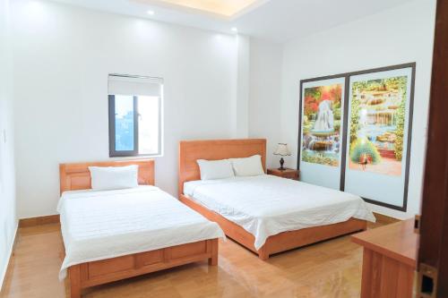 two beds in a room with white walls at Luxury Airport Hotel & Travel in Noi Bai