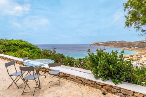 a glass table and chairs on a balcony with the ocean at Calma Beach House in Elia Beach