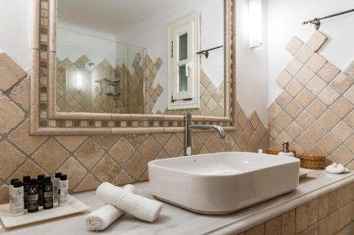 a bathroom with a white sink and a mirror at Calma Beach House in Elia Beach