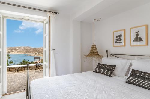 a bedroom with a bed and a view of the ocean at Calma Beach House in Elia Beach