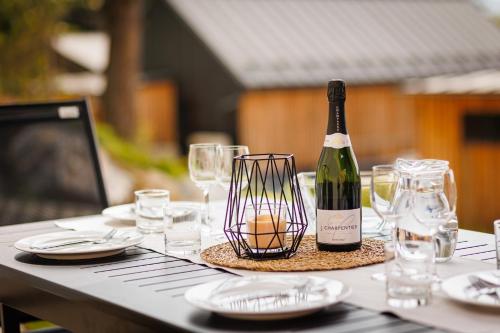 a bottle of wine sitting on a table with glasses at TRI VODY Demänovská Dolina in Liptovský Mikuláš