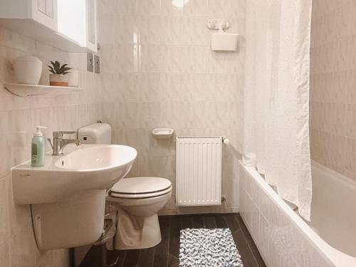 Baño blanco con aseo y lavamanos en Szilas Lak en Budapest