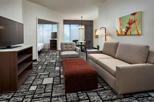 a living room with a couch and a flat screen tv at Best Western Plus Meridian Inn & Suites, Anaheim-Orange in Orange