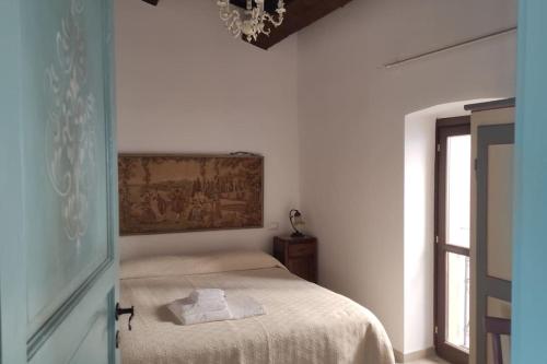 een slaapkamer met een bed en een schilderij aan de muur bij Il Racconto Aria in Nocera Umbra