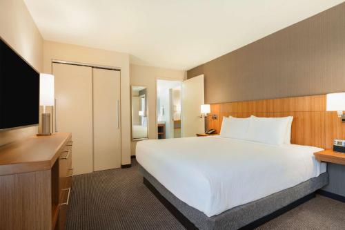 a bedroom with a large white bed and a television at Hyatt Place Houston/The Woodlands in The Woodlands
