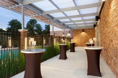 a patio with a row of tables and a pool at Hyatt Place Houston/The Woodlands in The Woodlands