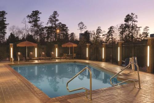 a swimming pool with lights on a fence at Hyatt Place Houston/The Woodlands in The Woodlands