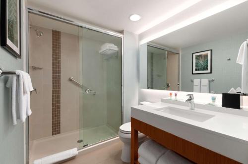 a bathroom with a shower and a sink and a toilet at Hyatt Place Houston/The Woodlands in The Woodlands