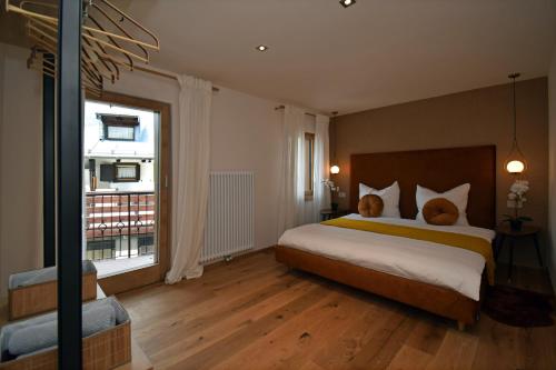 um quarto com uma cama grande e uma janela grande em Design Residence Nellere em Padola