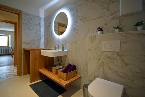 y baño con lavabo y espejo. en Design Residence Nellere, en Padola
