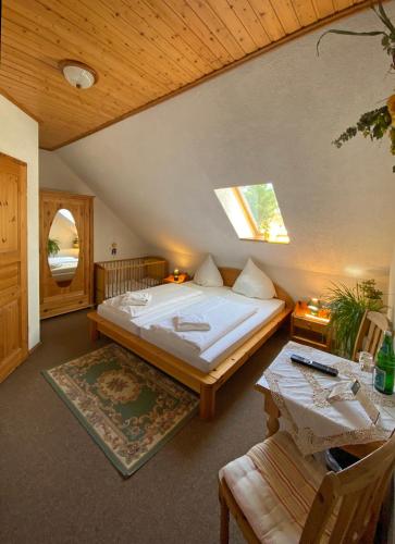 a bedroom with a large bed and a table at RATAGS Kunsthandwerkerhaus in Langenwolmsdorf